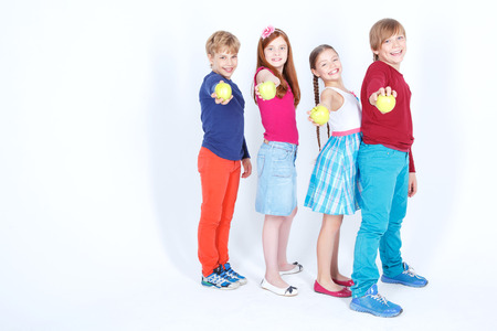 Feeling healthy. Full length of young cheerful friend holding apples in their hands.の写真素材