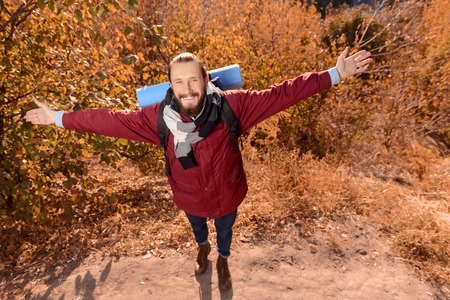 Elated agreeable cheerful man holding hands lifted and smiling while spending time outdoorの写真素材
