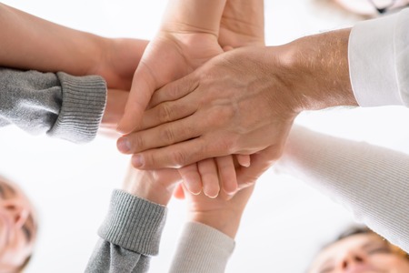 Be united. Low angle of hands of people holding them one on another during psychological group  therapy sessionの写真素材
