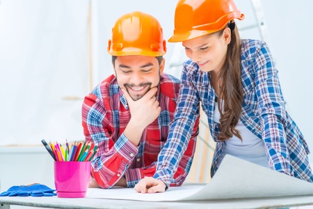 Pleasant smiling loving couple making plan of their dream house while going to make renovation