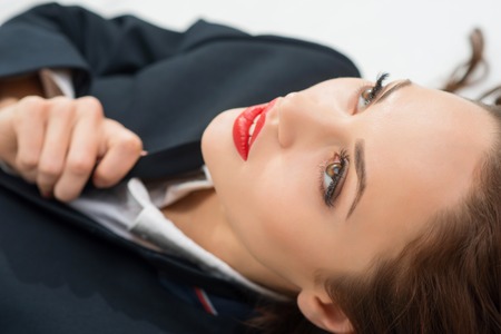 Look upwards. Young beautiful girl in male role is staring up without emotions.の写真素材