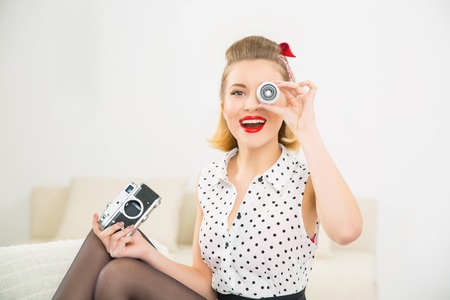 Girl with object glass. Young appealing smiling girl is looking through an object glass.