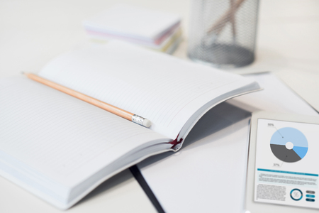 Keep it here. Close up of notebook with pencil lying on the table near the tabletの写真素材