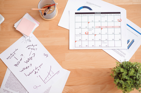 Busy tempo of life. Top view of sheets of paper lying on the surface of tableの写真素材