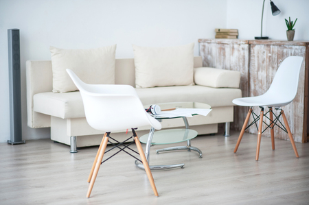 Smart space. View of white furniture specious room with chairs and sofaの写真素材