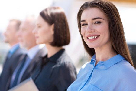 Head of the department. Positive cheerful beautiful woman smiling and expressing joy while standing...
