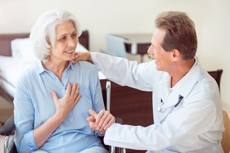 Helpful specialist. Positive senior woman and doctor talking with her and embracing