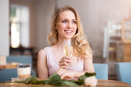 My happy day. Portrait of smiling young women holding glass of champagne and feeling happinessの写真素材