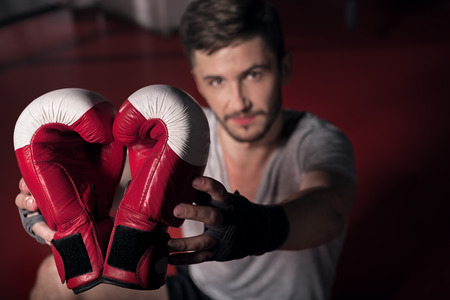My passion. Top view of boxing gloves held by young handsome man.