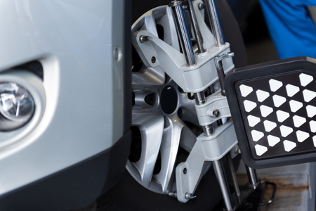 Close up of car tyre clamped in alignment machine device while being checkedの写真素材