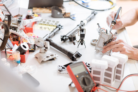 All stuff here. Close up of mans hands using mechanical equipment and drone details such as...