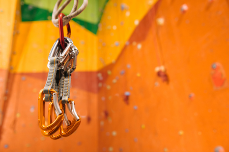 Waiting for you to come. Close up of climbing equipment hanging in orange climbing gym.の写真素材