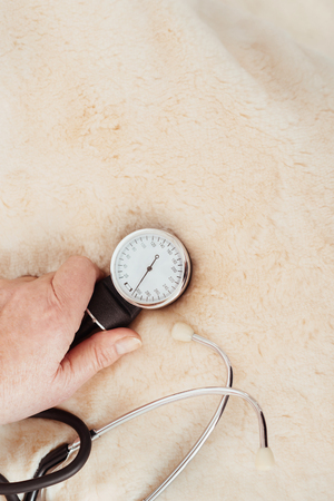 Control your pressure. Close up of tonometer in hands of pleasant elderly woman holding it on the...