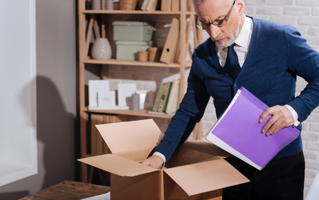 Broken senior man packing his thingsの写真素材