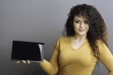 Confident female presenting new tabletの写真素材