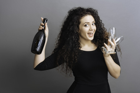 Joyful female holding black bottleの写真素材