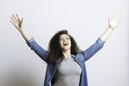 Positive delighted woman raising handsの写真素材