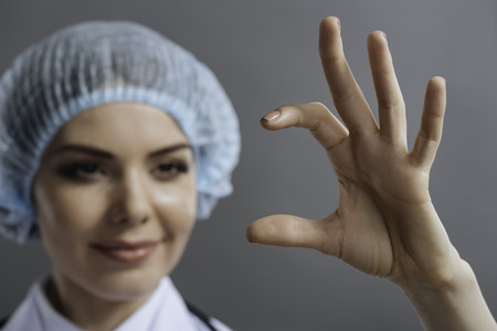 Close up of delighted doctor showing something with her handsの写真素材