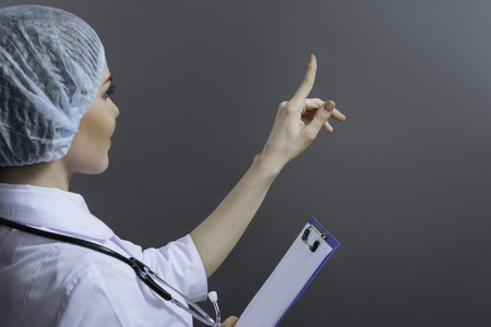 Attractive female doctor pointing somewhere with her fingerの写真素材