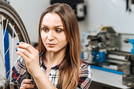 Beautiful craftswoman pumping the wheel in the workshopの写真素材