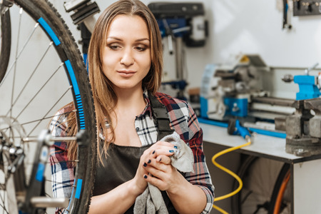 Smiling young craftswoman relaxing in the garageの写真素材
