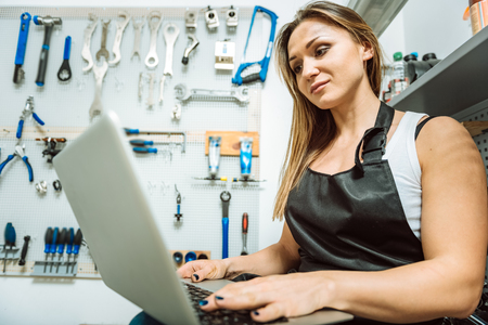 Delighted female technician relaxing and using the laptopの写真素材