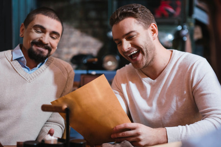 Happy handsome men looking at the menuの写真素材