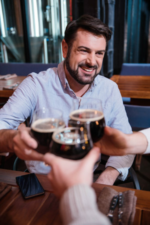 Handsome bearded man cheering with his friendsの写真素材