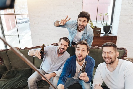 Delighted elated men using a selfie stickの写真素材