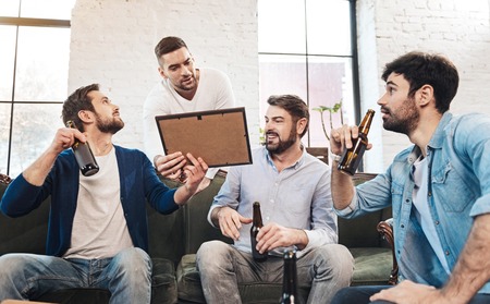 Nice pleasant man standing behind the sofaの写真素材