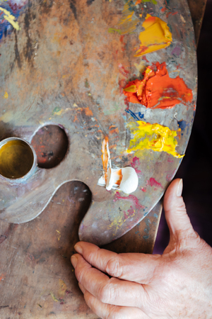 Close up of female artists hands holding paintsの写真素材