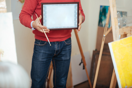 Close up of young man demonstrating a painters diplomaの写真素材