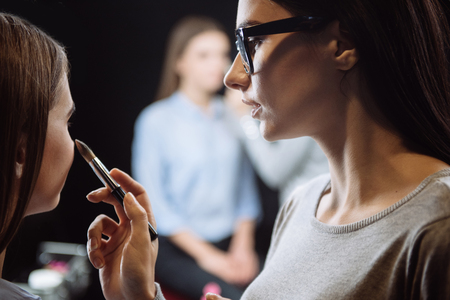 Nice skillful visagiste using a makeup brushの写真素材