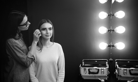 Nice professional makeup artist working with eyebrowsの写真素材