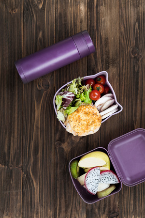 Tasty cutlet lying on salad leaves in lunch boxの写真素材