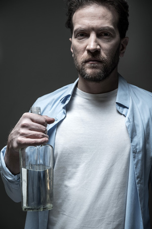 Serious man holding beverage in right handの写真素材