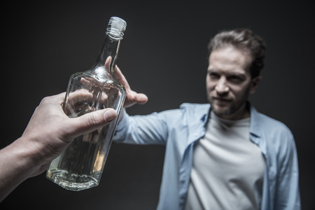 Close up of male hand giving bottleの写真素材