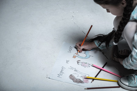 Close up of picture being painted by little girlの写真素材