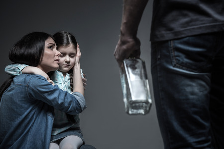 Dependent on alcohol man threatening his wifeの写真素材