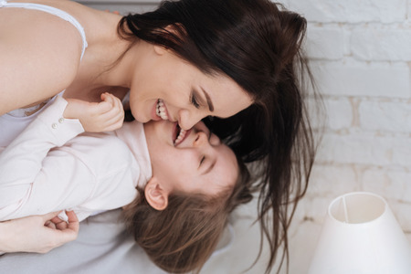 Delighted nice woman enjoying time with her daughterの写真素材