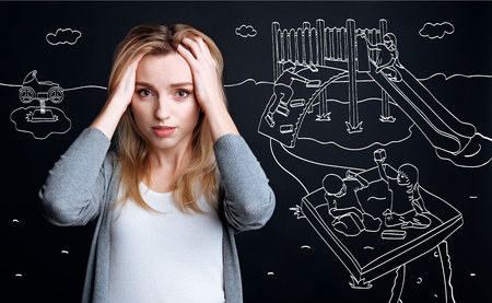 Beautiful worried mother holding her headの写真素材