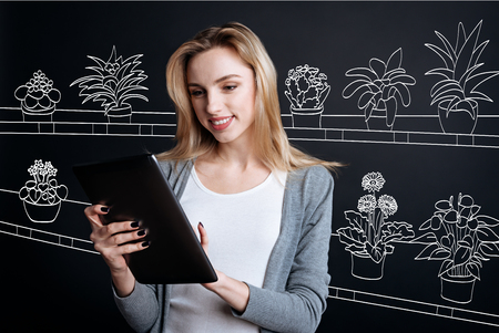 Delighted positive woman working with a tabletの写真素材