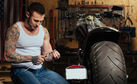Delighted brutal man looking at instrumentの写真素材