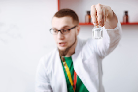 Nice handsome scientist holding a small bottleの写真素材