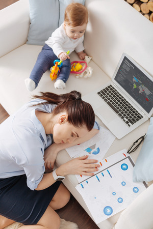 Strong young mother taking a break from workingの写真素材