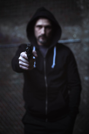 Angry dark man threatening with a gunの写真素材