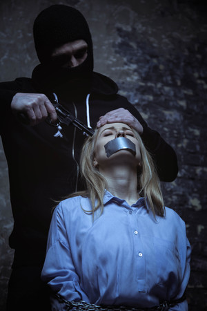 Dangerous evil hotheaded man making threats to a businesswomanの写真素材