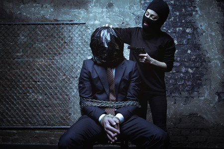 Cruel brutal heated kidnapper torturing a hostageの写真素材