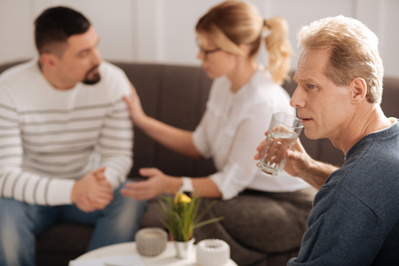 Sad unhappy man drinking waterの写真素材