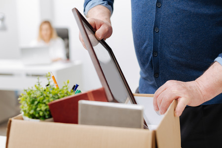 Fired man gathering personal belongings into the boxの写真素材